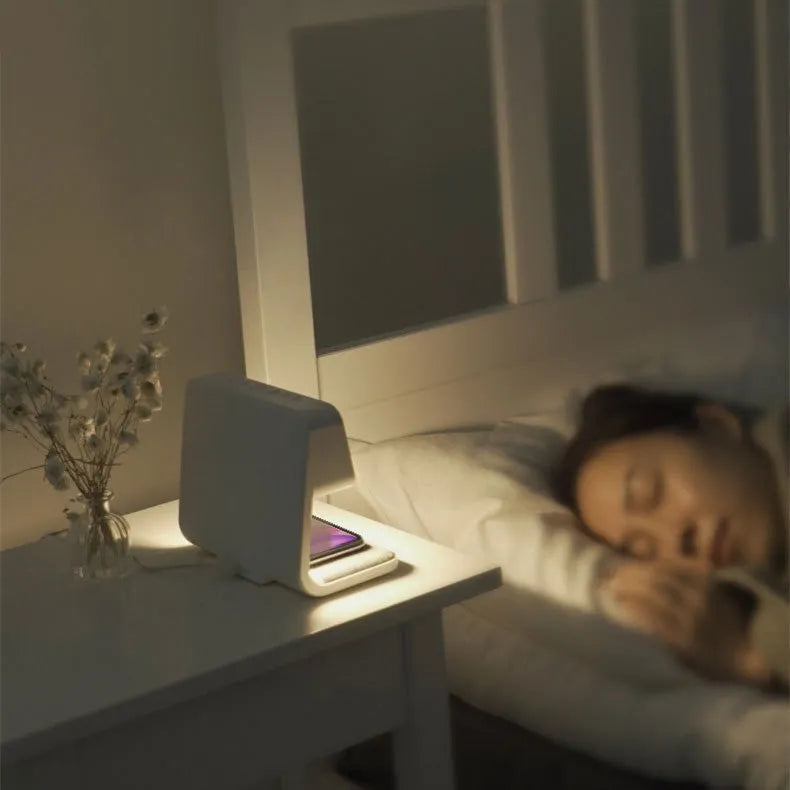 White 3-in-1 bedside lamp with wireless charging pad, LCD clock display, and touch controls.