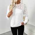 White loose fit long sleeve women's top with floral pattern, laid flat.