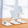 Black and white desktop phone stand with wireless charging on a wooden desk.