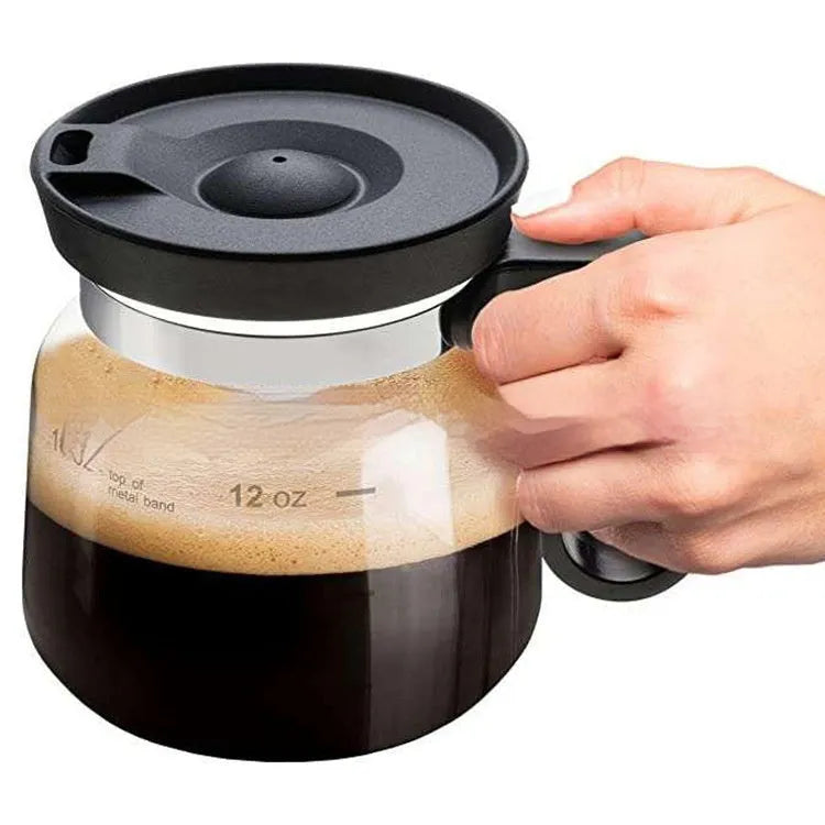 Transparent borosilicate glass coffee maker with a black silicone cover on a kitchen counter.