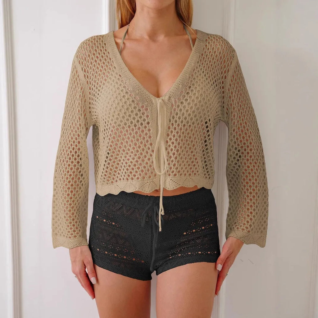 Short apricot hollow woven women's cardigan blouse with bell sleeves laid flat.
