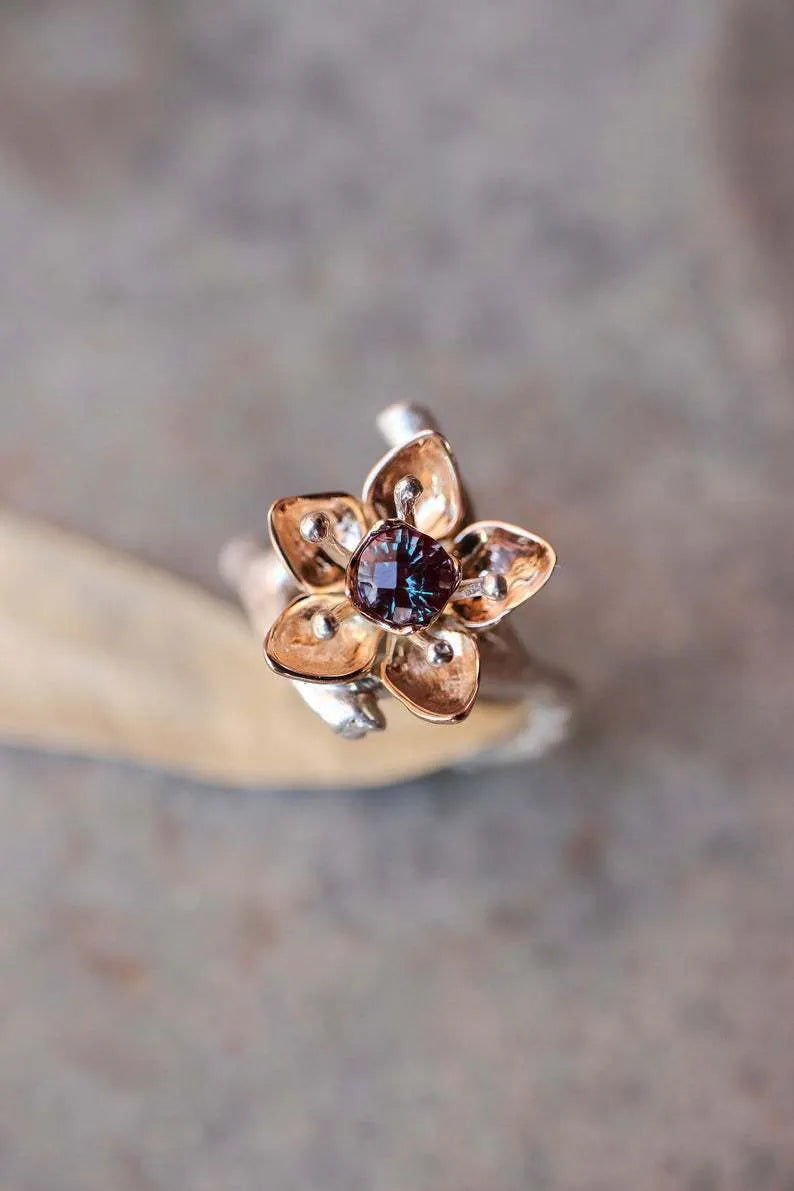 Silver two-tone alloy women's ring with geometric floral pattern on a finger.