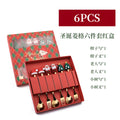 Red stainless steel Christmas spoon and fork set with tree and snowman patterns on handles