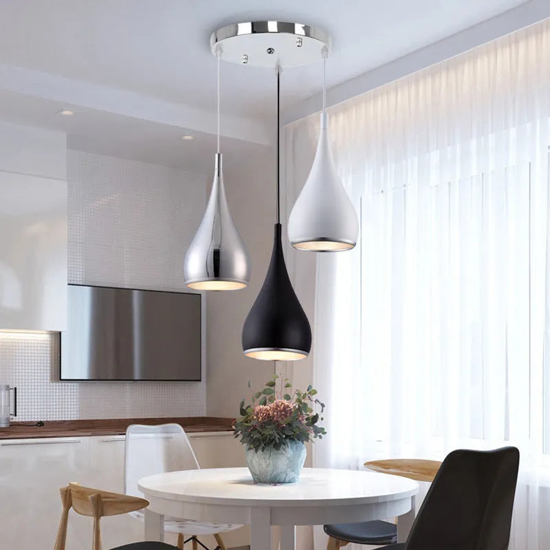 Minimalist iron pendant chandelier with three adjustable heads in a black finish, hung from a ceiling.