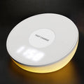 White wireless charging pad with digital clock display and night light, shown on a wooden surface.