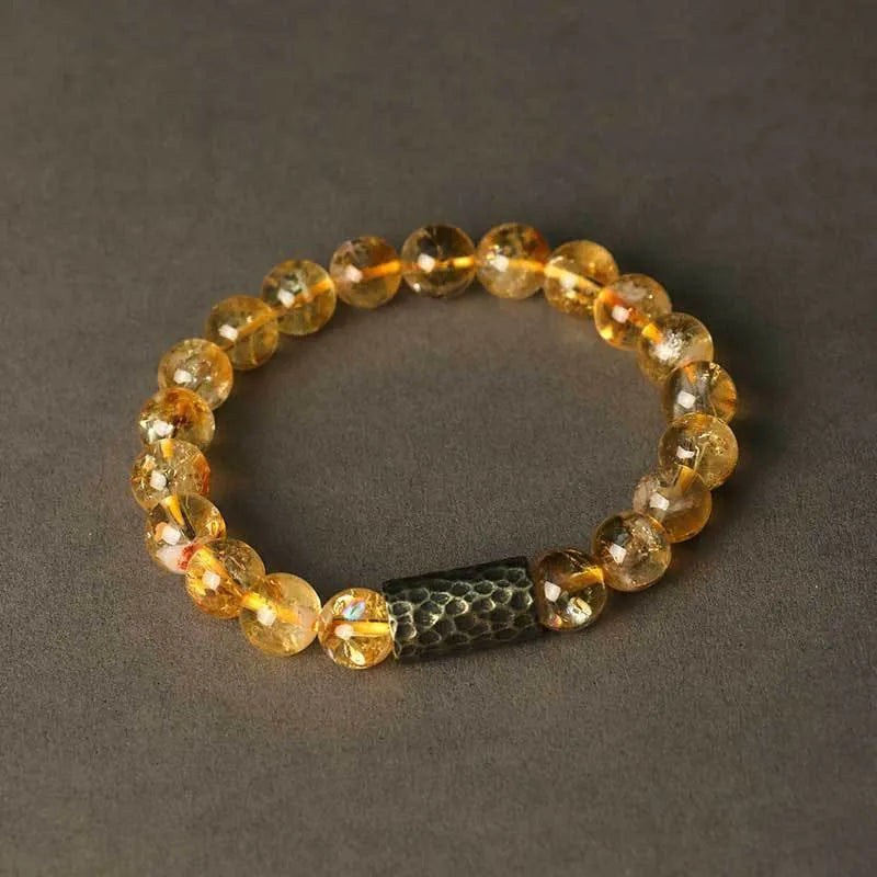Handmade yellow tower crystal bracelet with double ring design on wrist.