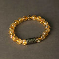 Handmade yellow tower crystal bracelet with double ring design on wrist.