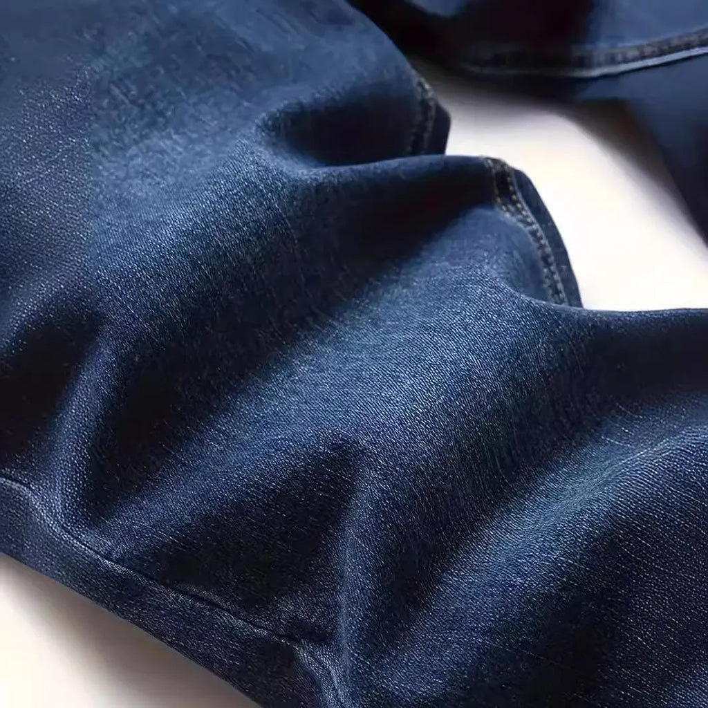 Man wearing dark blue slim fit skinny jeans with a mid-rise waist and zipper fly.
