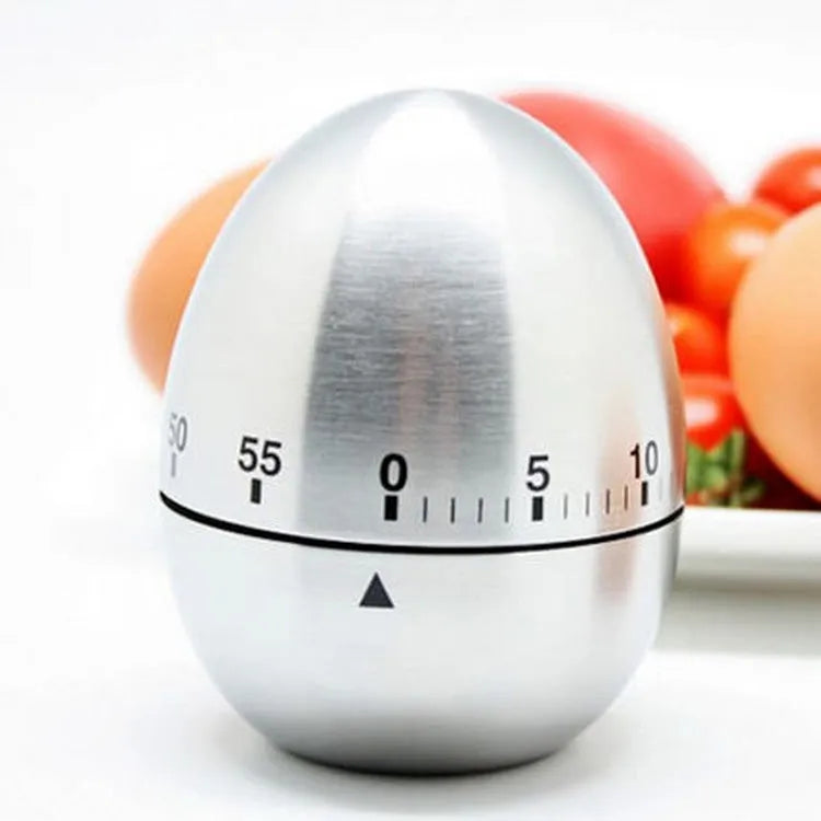 Stainless steel egg-shaped mechanical kitchen timer on a kitchen countertop