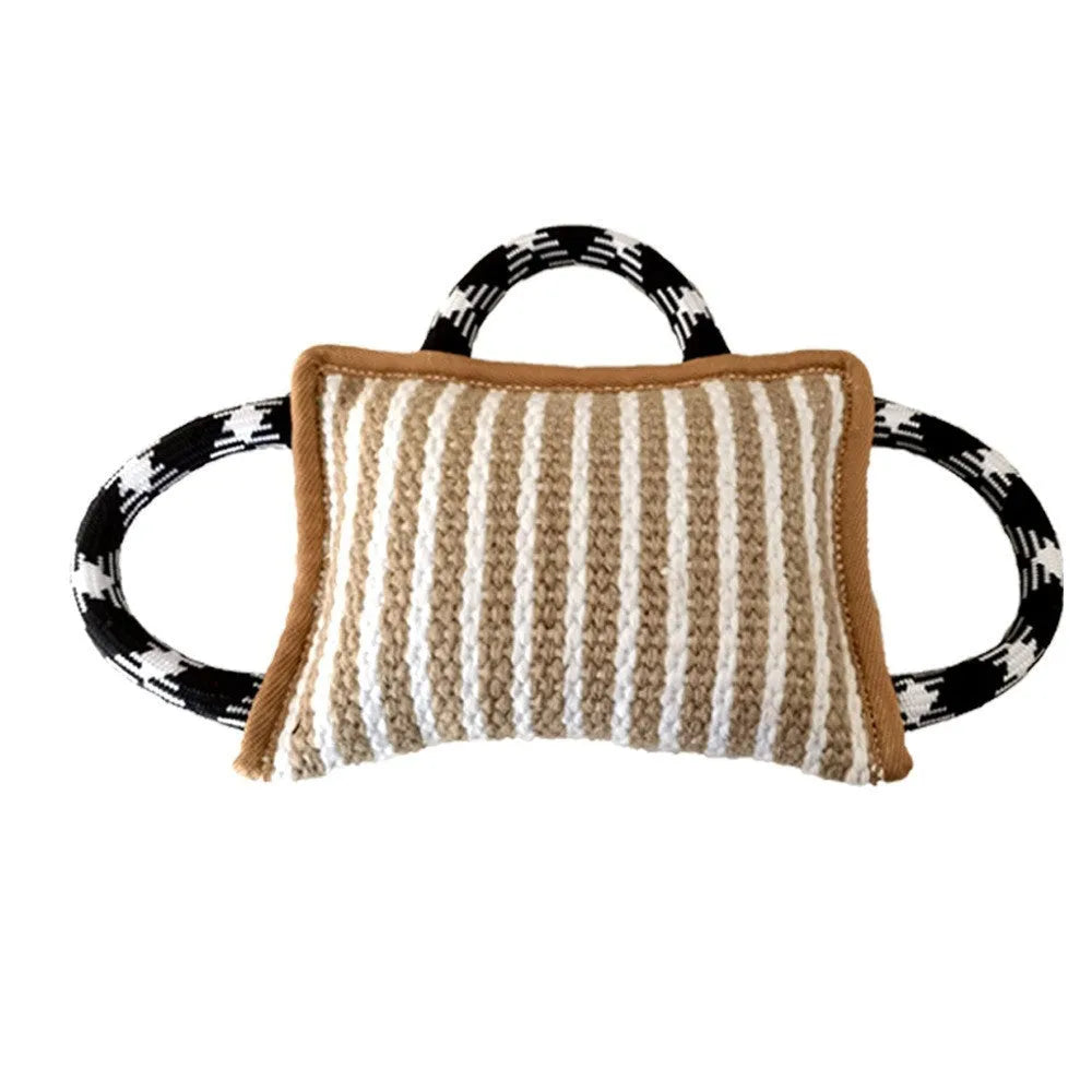 Jute dog tug toy with three rope handles and a central bite pillow, shown in assorted colours.