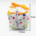 Four soft plush dog birthday toys: large cake, small cake, gift box, and bones on neutral background