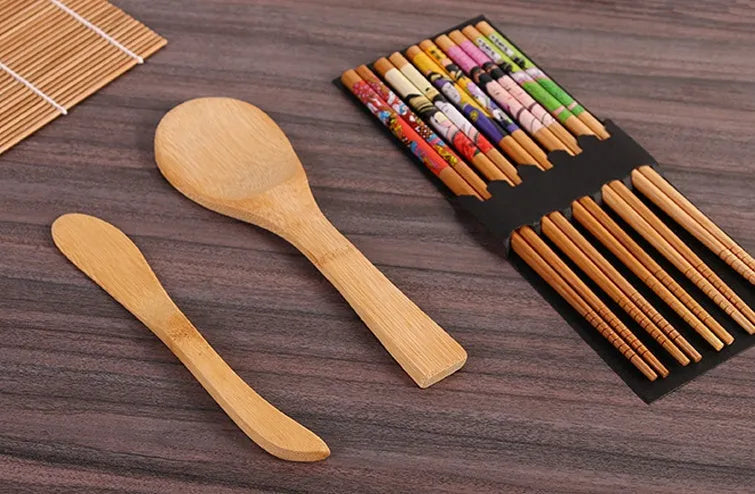 White sushi tool set with bamboo rolling mat and spatula on a kitchen counter