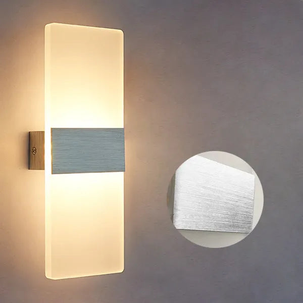 Modern acrylic wall-mounted LED bedside lamp in silver finish showing warm light illumination