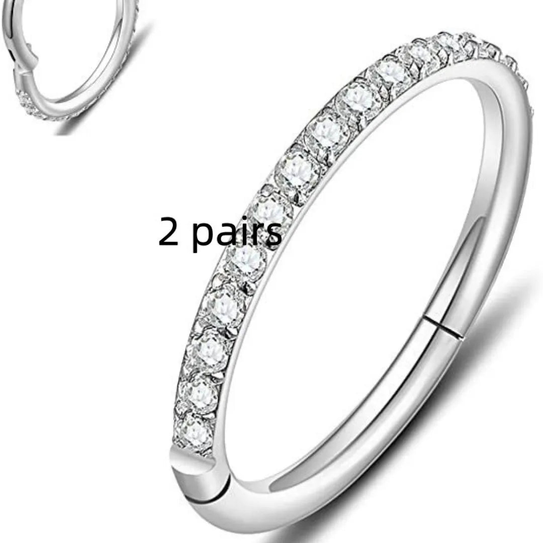 Close-up of a stainless steel seamless nose ring with a small diamond detail, shown in a gold plating colour.