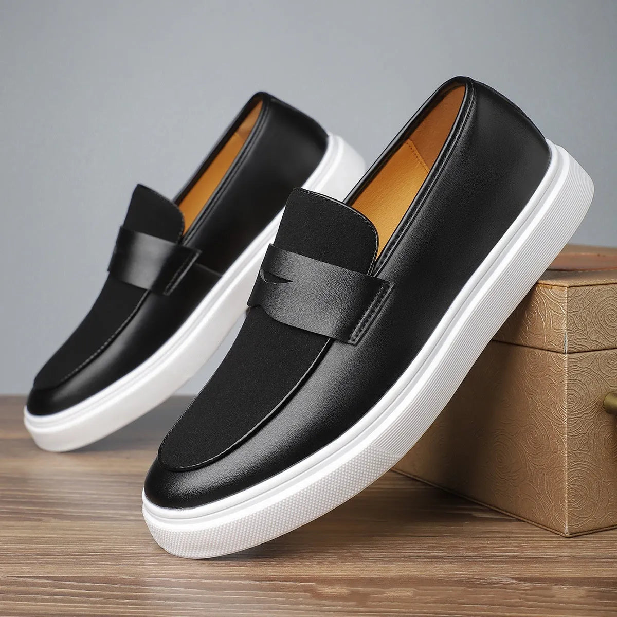 Men's black slip-on casual Gommino-style shoes with round toe and tassel decoration on a flat mid-heel.