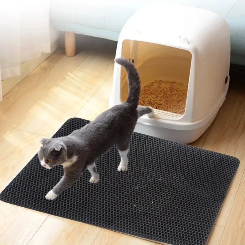 Black EVA foam cat litter pad with honeycomb design beside litter box