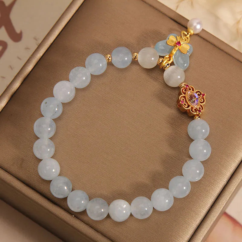 Women's adjustable bracelet with an aquamarine crystal butterfly pendant and rhinestone details on a metal chain.
