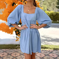 Orange children's backless dress with square collar and puff sleeves on a hanger.