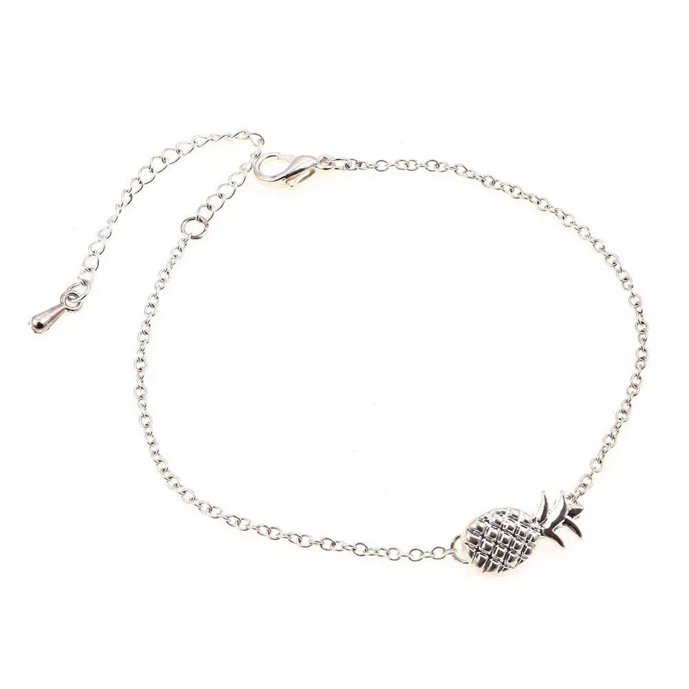 Close-up of a women's alloy bracelet with a detailed pineapple charm in gold or silver colour.
