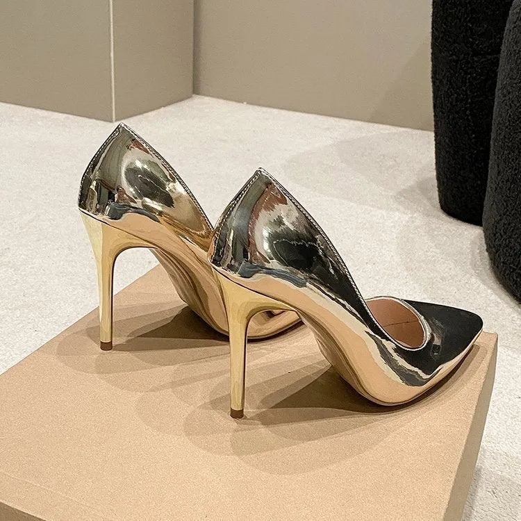 Gold and silver pointed toe slip-on stiletto heel pumps on a white background