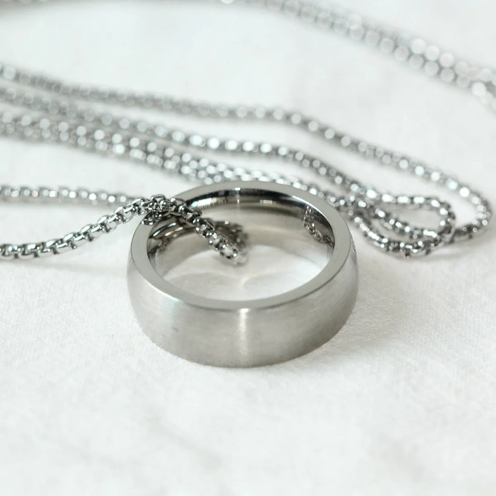 Men's silver stainless steel pearl chain necklace with titanium steel circle pendant on grey background