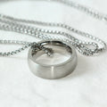Men's silver stainless steel pearl chain necklace with titanium steel circle pendant on grey background