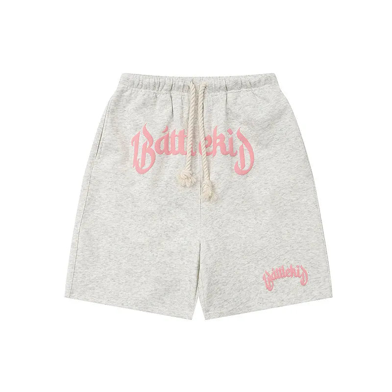 Men's black cotton loose-fit street style cropped shorts on a grey background.