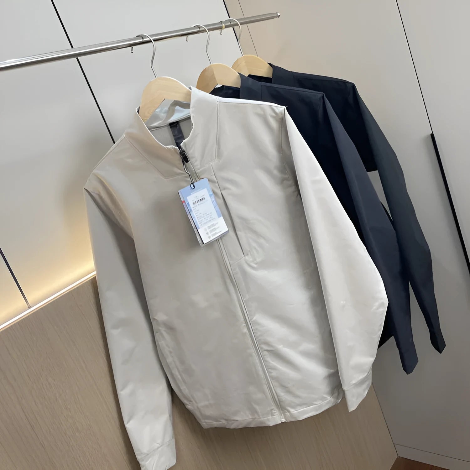Man wearing a milky white stand collar casual jacket with long sleeves and a straight hem.
