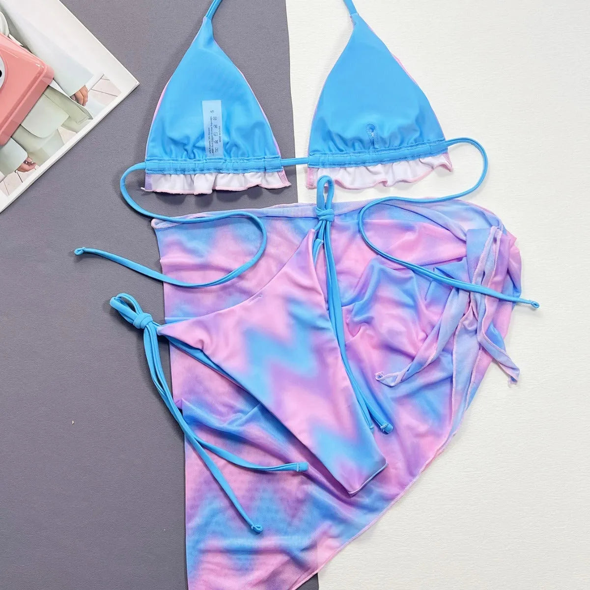 Women's split tie-dye bikini swimsuit set with matching skirt on mannequin