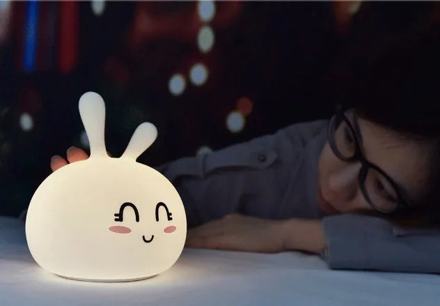 White marshmallow bunny LED night light with shy face or happy face option on a table.