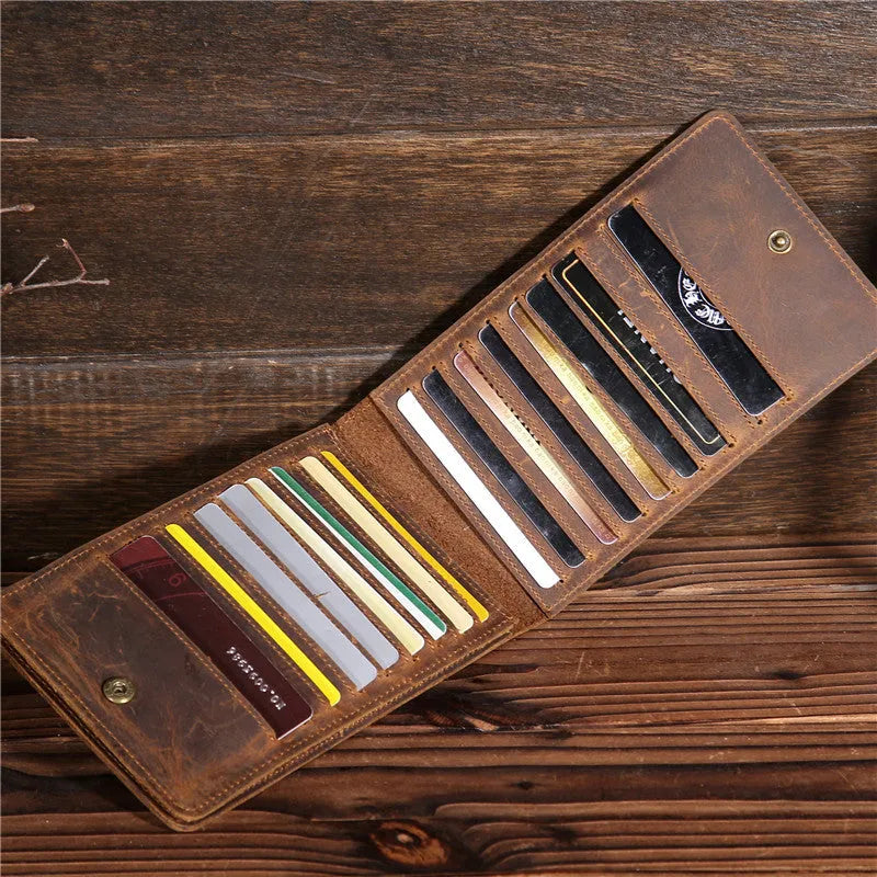 Slim brown cowhide men's wallet open to show 18 card slots and a phone compartment.