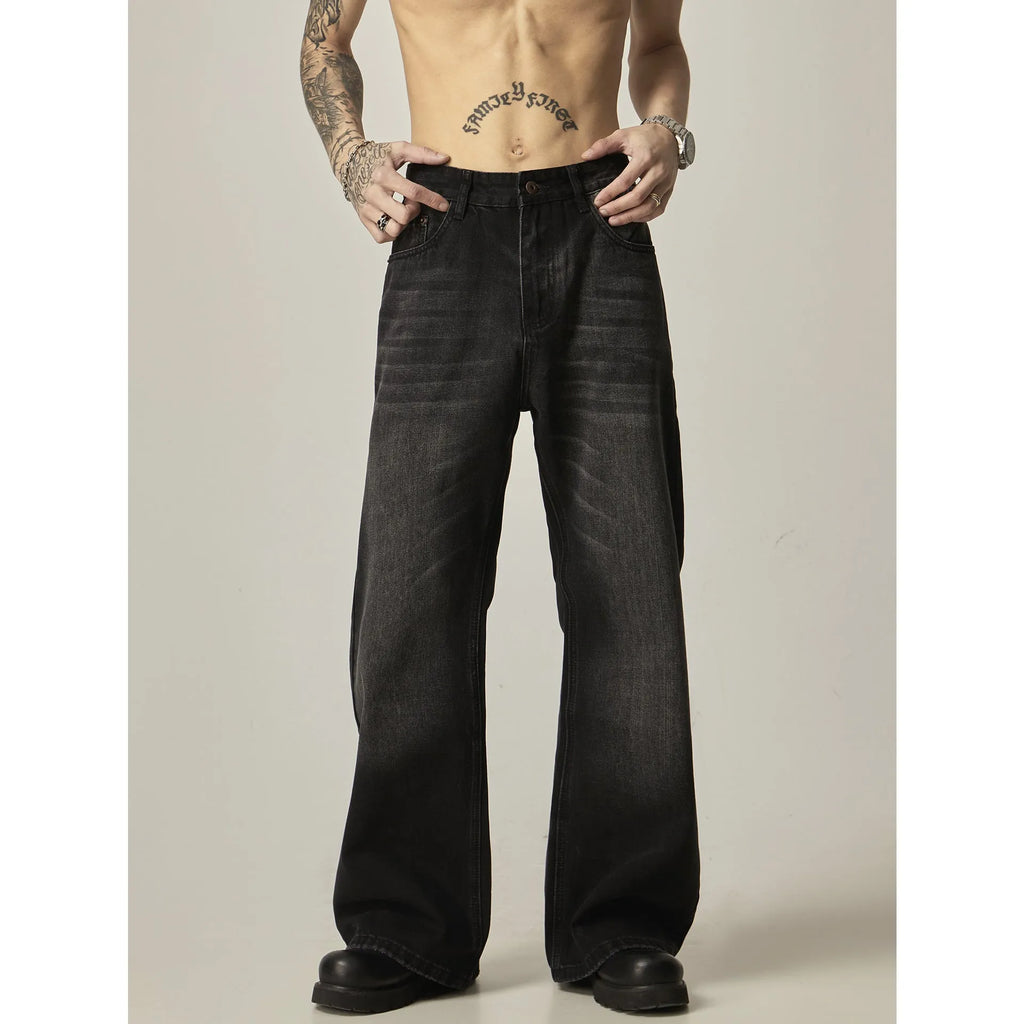 Black loose-fit straight leg denim jeans with a zipper fly on a neutral background.