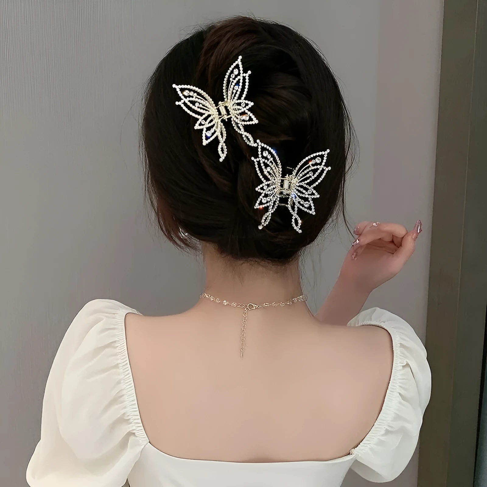 Butterfly-shaped alloy hair clip for women with rhinestone or pearl decoration.