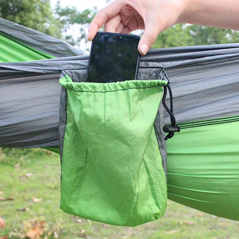 Sapphire blue parachute nylon hammock hung between two trees, showing its full 270cm length and integrated ropes.