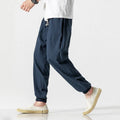 Men's cotton linen harem trousers in beige, shown with elastic waistband and tapered legs, available in multiple sizes and colours