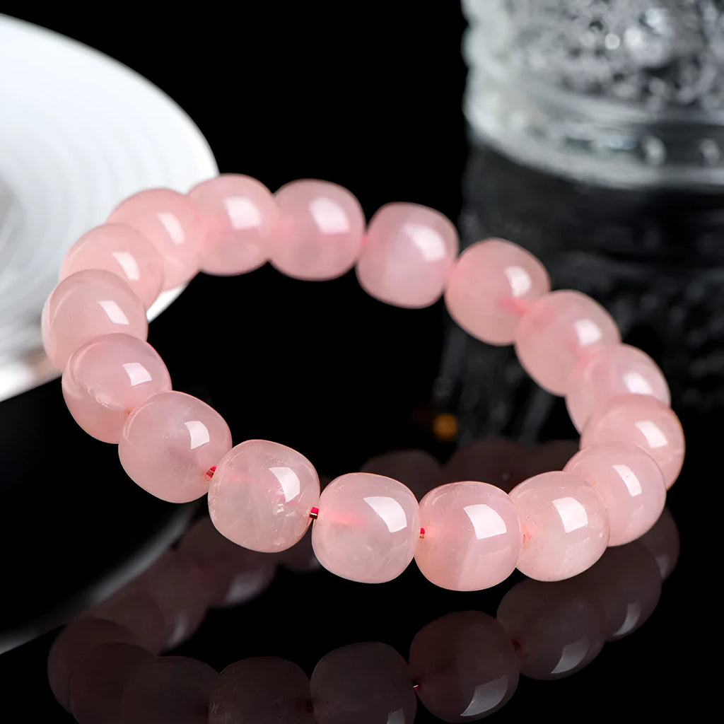 Pink natural crystal barrel bead bracelet with geometric design on wrist