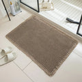 Square checkered pattern non-slip bathroom carpet on tiled floor in beige colour.