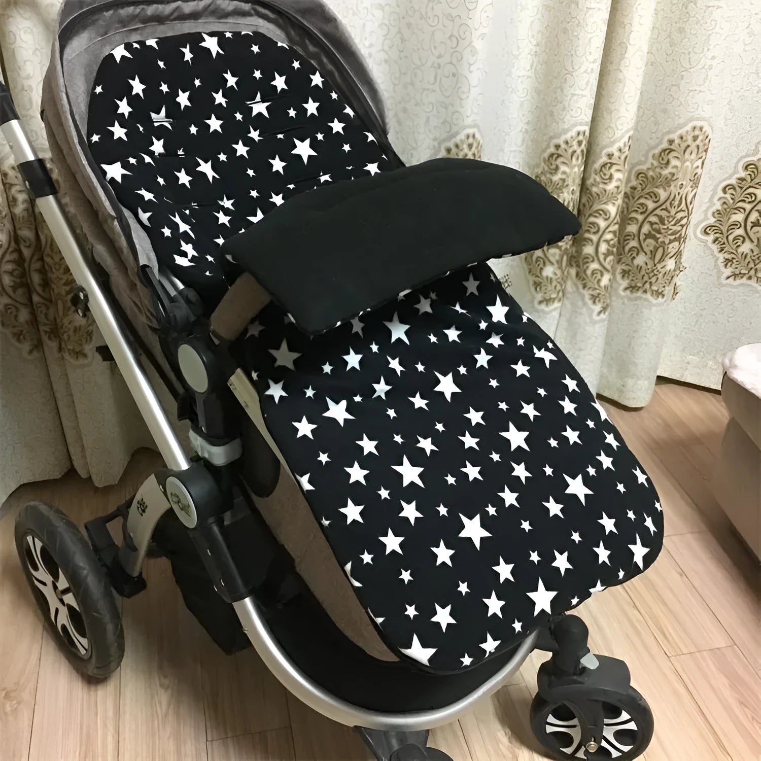 Envelope-style baby stroller sleeping bag in beige colour with thick filling, shown next to a pram.