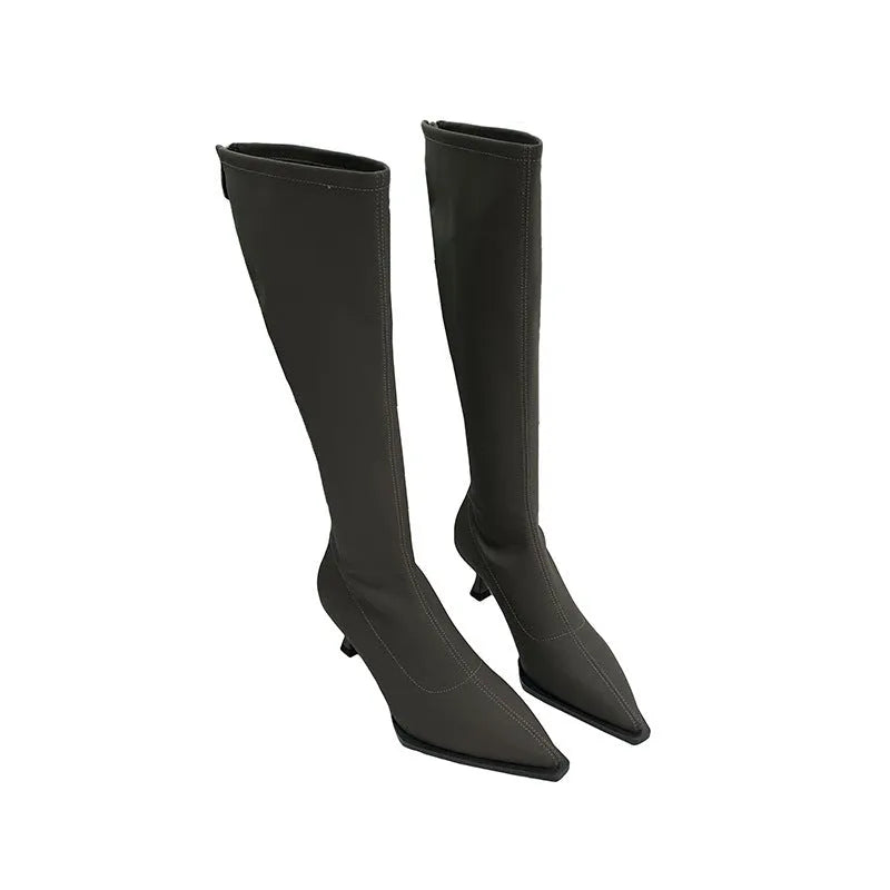 Women's pointed toe knee-high boots in black with a stiletto heel and a visible back zipper closure.