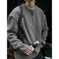 A solid colour loose pullover top for women in grey, shown as a layering piece.