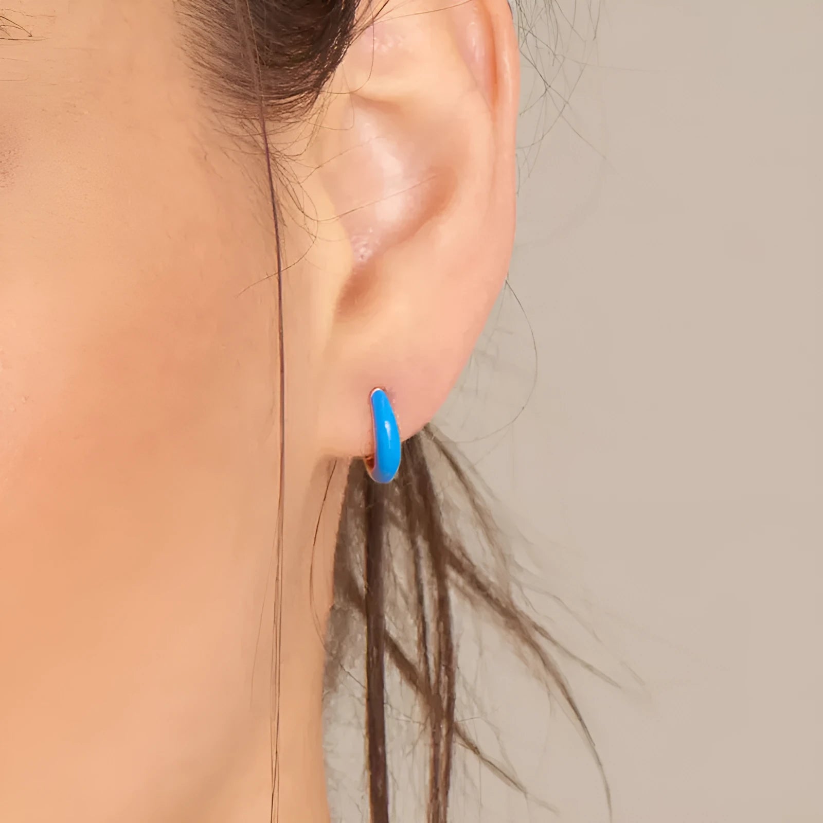 A pair of glossy, U-shaped epoxy oval earrings with a round ring detail on silver copper posts.