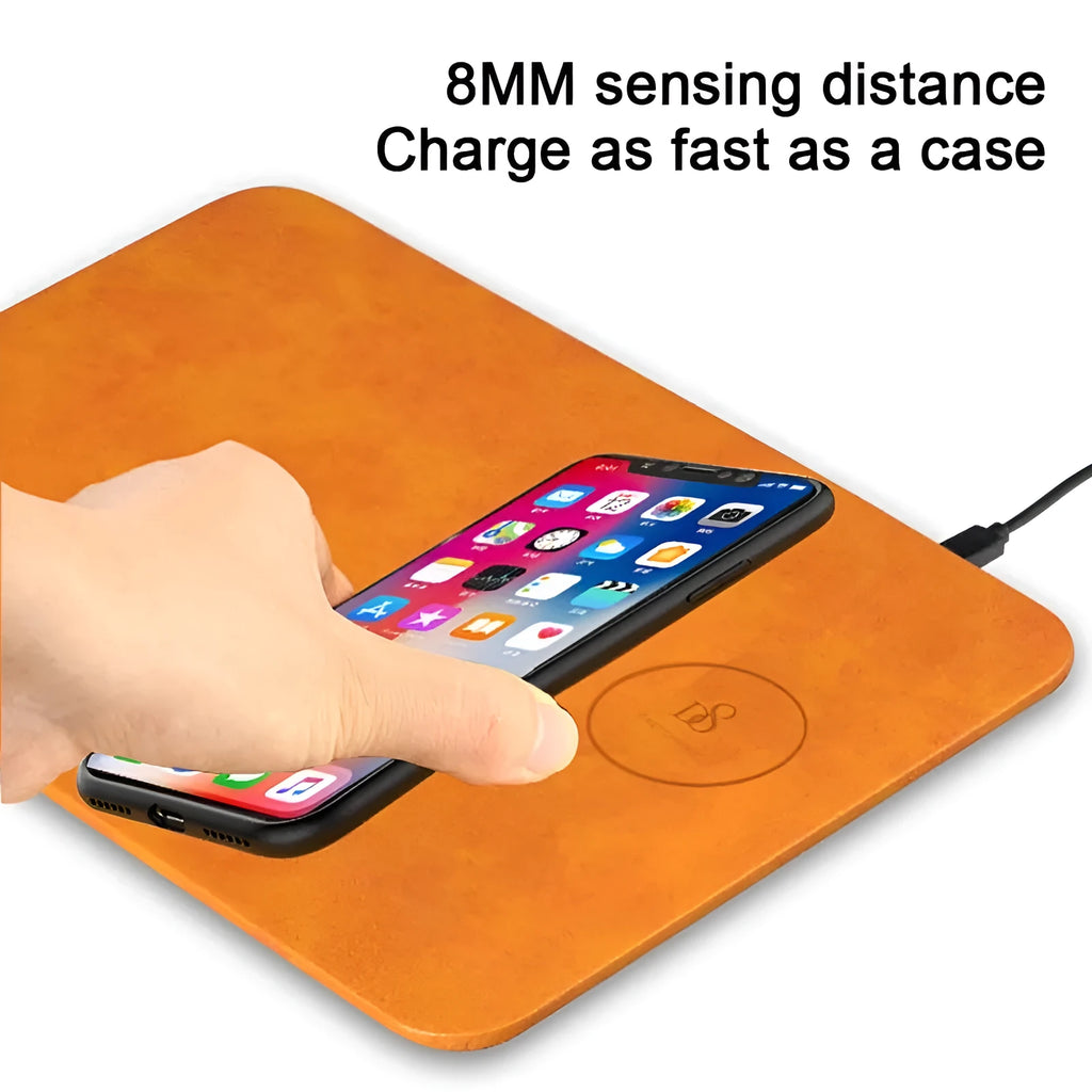Brown leather desk mat with integrated wireless charging pad for mobile phones on a wooden desk.