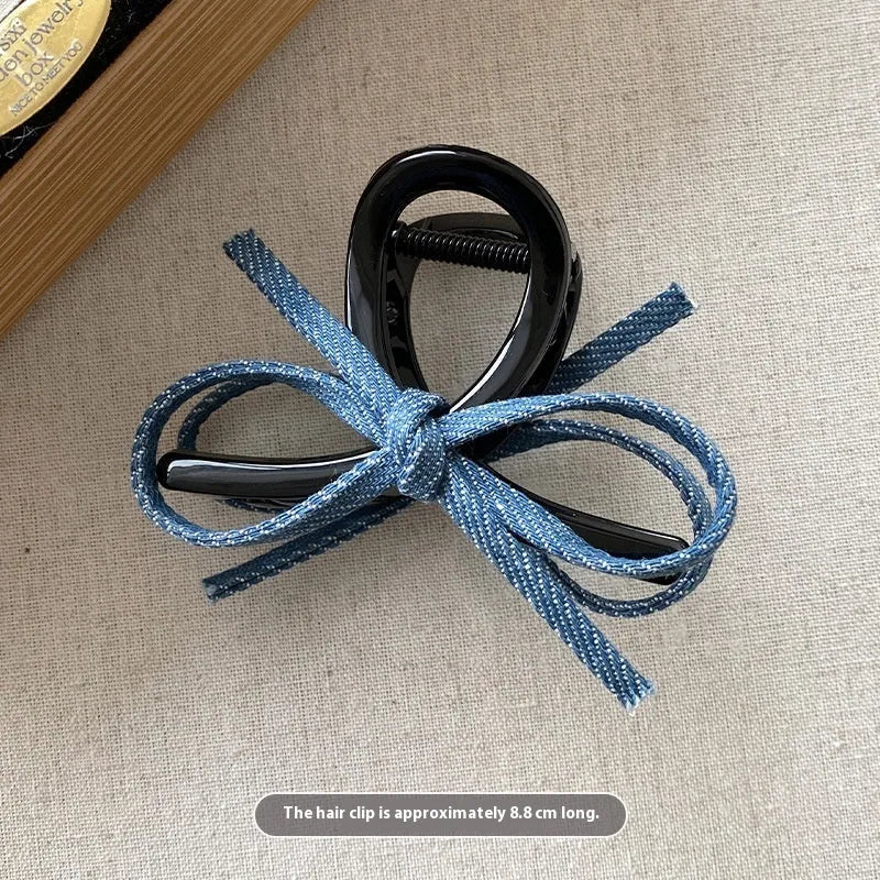 Denim blue bow hair barrette for women with metal clip, shown as a cloth bow hair accessory