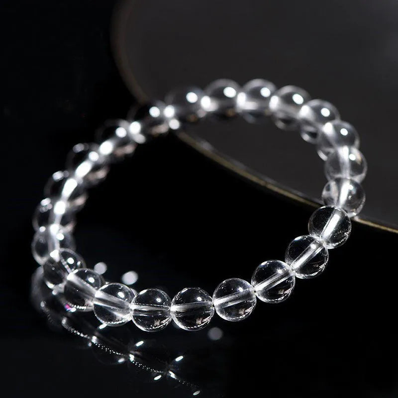 Natural white crystal bead bracelet with geometric design on a wrist.