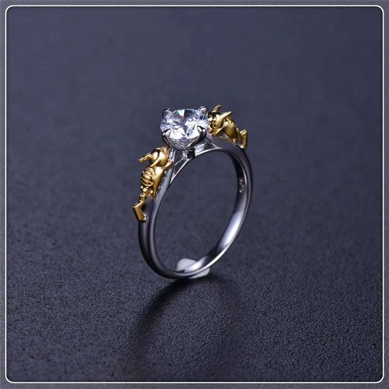 Detailed close-up of a black gold copper crown ring with a central crystal on a finger.