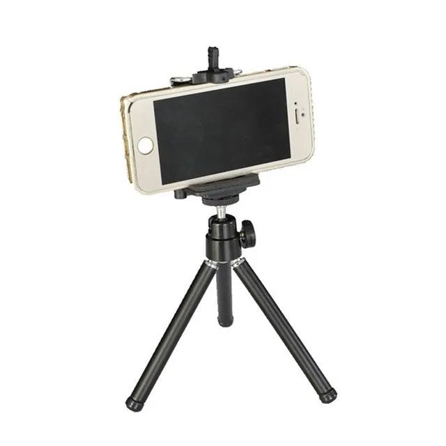 Mini aluminium tripod with extended legs and a black U-shaped phone clip attached