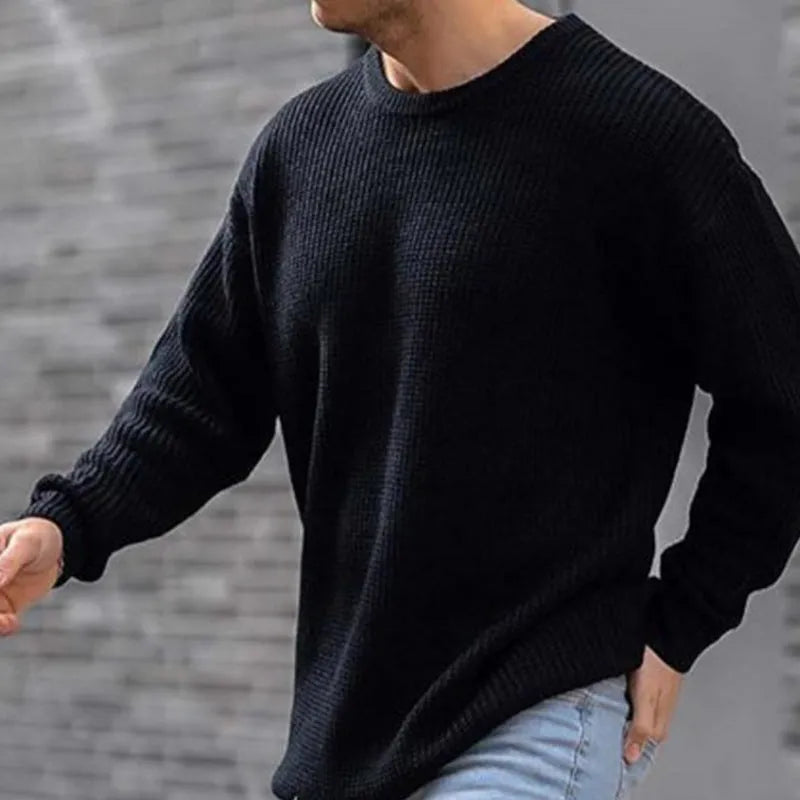 Men's solid colour round neck long sleeve acrylic sweater in black, folded flat on a white background