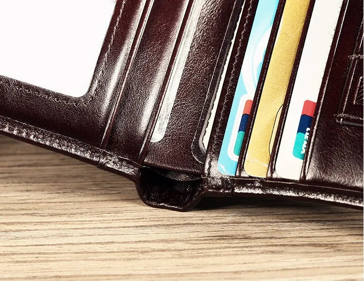 Men's black genuine leather bi-fold wallet open, showing eight card slots, a note compartment, and a zipped coin pouch.