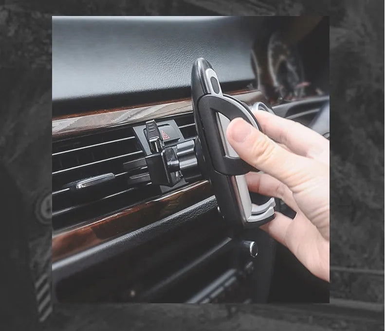 Black plastic universal mobile phone holder attached to a car air conditioning vent.