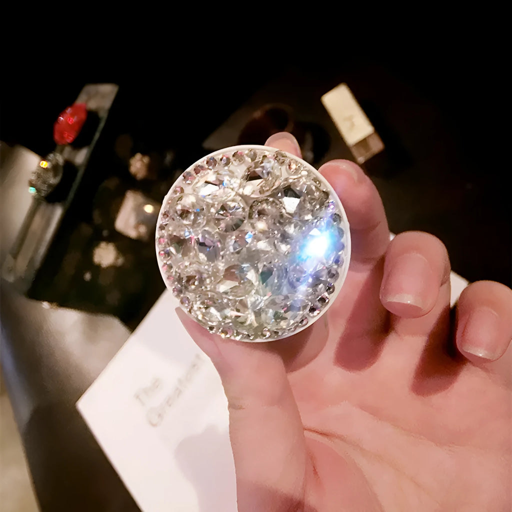Rhinestone-decorated airbag-style car phone holder with telescopic bracket extended, showing 360-degree swivel mechanism.